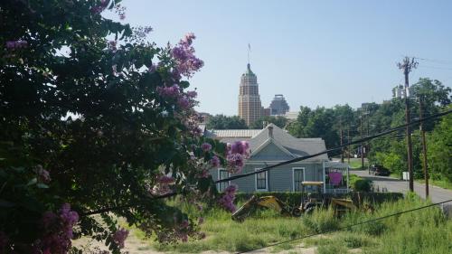 a house on the side of a street with purple flowers at La Villita Inn in San Antonio