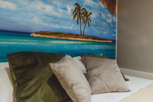 una camera da letto con un dipinto di una spiaggia e di palme di De Luca Luxury b&b a Napoli