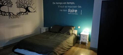 a bedroom with a bed with a quote on the wall at Gîte de La Bicyclette in Montournais