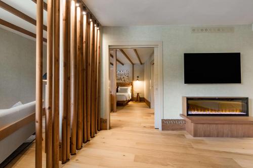 a hallway with a fireplace and a tv on a wall at Grand Hotel Savoia Cortina d'Ampezzo, A Radisson Collection Hotel in Cortina dʼAmpezzo