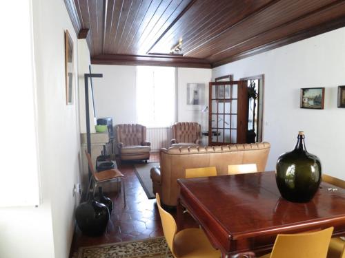 a living room with a wooden table and chairs at Casa de Santo Amaro in Vila do Conde