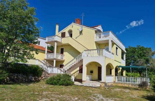 a large yellow house with white balconies on it at Hilltop Villa Risika in Risika