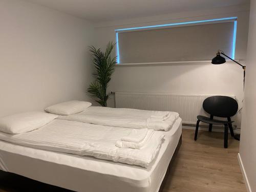 a bedroom with a bed and a chair and a window at Day Dream Soleyjargata Rooms & Apartments in Reykjavík