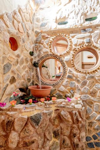 a stone wall with three mirrors and a sink at Hospedaje Solentiname in Medellín