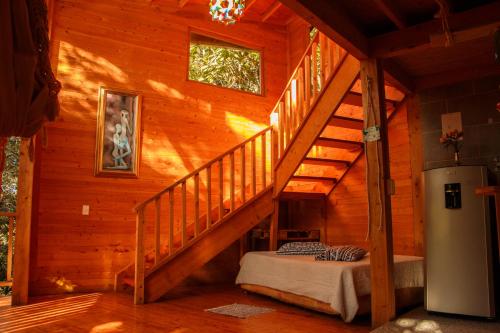 a wooden cabin with a staircase and a refrigerator in it at Hospedaje Solentiname in Medellín
