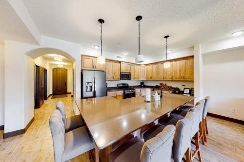 a dining room and kitchen with a long table and chairs at Estancia Enchantment in St. George