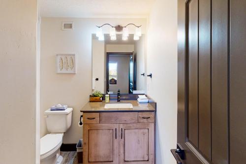 a bathroom with a sink and a toilet and a mirror at Estancia Enchantment in St. George