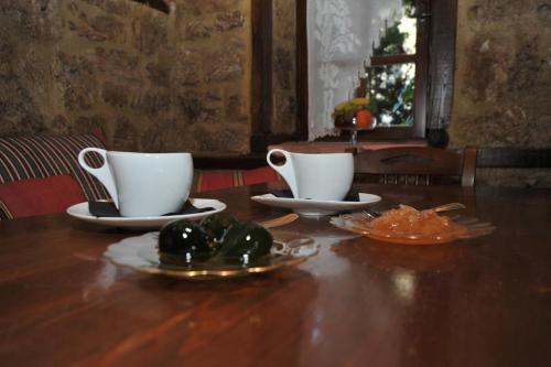 a wooden table with two cups and plates on it at Varosi Guesthouse in Edessa
