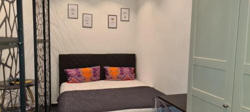 a small bed with two pillows in a room at Design-Apartment mit Klimaanlage & Top-Anbindung an der U1 in Vienna