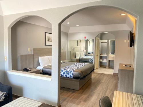 Island Suites Hobby Airport في هيوستن: غرفة فندقية بسريرين ومرآة