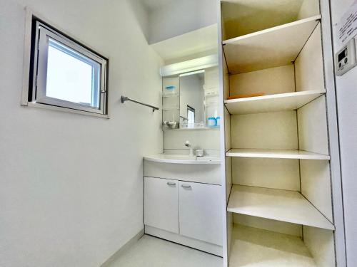 a small bathroom with a sink and a mirror at Villa Izumizaki in Naha