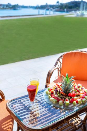 a plate of fruit on a table with a drink at Golden Lake Marina Hotel in El Alamein