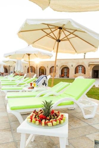 a row of lounge chairs with a plate of fruit at Golden Lake Marina Hotel in El Alamein