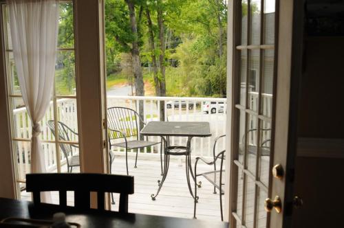 a porch with a table and chairs on a deck at Acorn Hill Lodge and Spa in Lynchburg