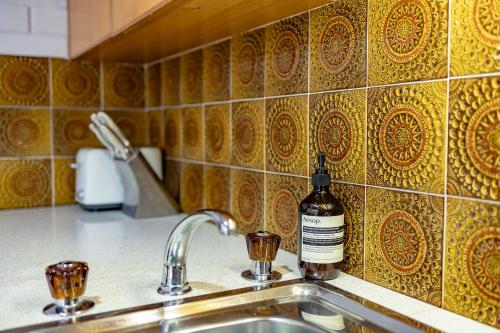 Uma garrafa de álcool está sentada num lavatório da cozinha. em The Flaxman Studio - Panoramic Ocean Views em Port Lincoln