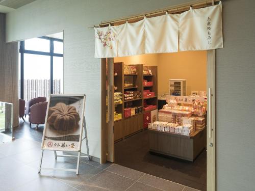 a store with a door open to a room with food at Grandvrio Hotel Miyajima Wakura - ROUTE INN HOTELS - in Miyajima