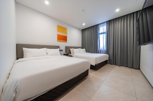 a hotel room with two beds and a window at Hotel RU136 in Seoul