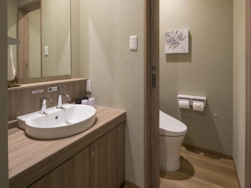 a bathroom with a sink and a toilet at Grandvrio Hotel Miyajima Wakura - ROUTE INN HOTELS - in Miyajima