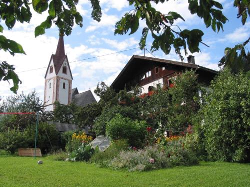 a church with a steeple and a garden with a church at Genusshof Mesner Aktiv in Liesing