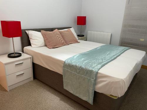 a bedroom with a large bed with two lamps on it at GREENWICH CENTRE NKY APARTMENT in London