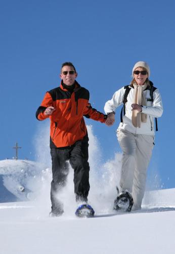 a man and woman standing in the snow on snowboards at Genusshof Mesner Aktiv in Liesing