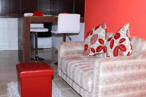 a living room with a couch and a red wall at Zurisadai in Puerto Ayora