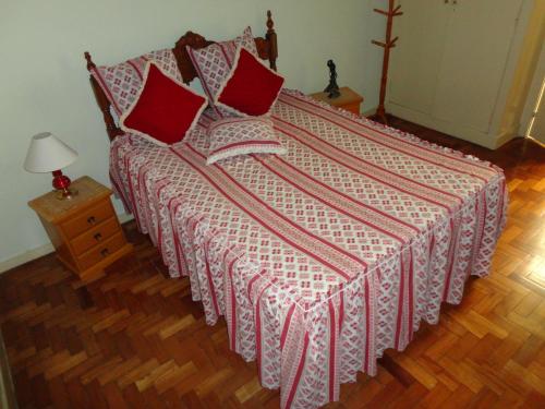 uma cama com almofadas vermelhas num quarto em Rio Apartamento - Copacabana no Rio de Janeiro