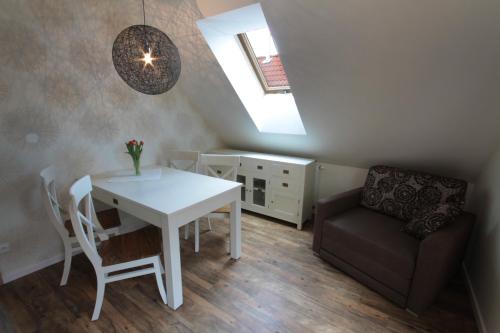 a dining room with a white table and a chair at Hotel Bílý jednorožec in Třeboň