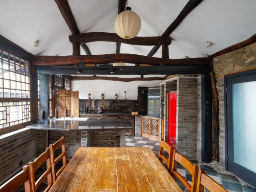 a kitchen with a long wooden table and chairs at Brickyard Retreat at Mutianyu Great Wall Adjoin to Mutianyu Great Wall - Room with the View of Great Wall - Chinese massage experience - Vehicle Shuttle Service - International Catering - SPA& Nail Beauty Facilities in Huairou