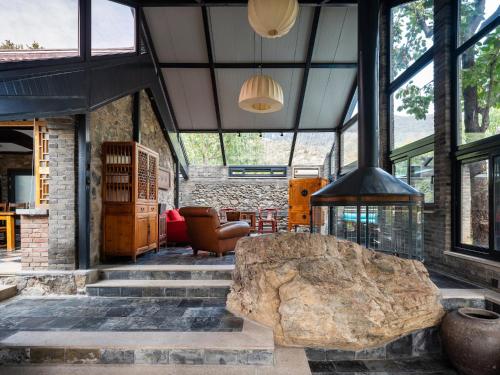 a large rock in the middle of a room with a fireplace at Brickyard Retreat at Mutianyu Great Wall Adjoin to Mutianyu Great Wall - Room with the View of Great Wall - Chinese massage experience - Vehicle Shuttle Service - International Catering - SPA& Nail Beauty Facilities in Huairou