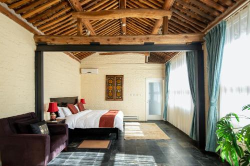 a bedroom with a bed and a couch in a room at Brickyard Retreat at Mutianyu Great Wall Adjoin to Mutianyu Great Wall - Room with the View of Great Wall - Chinese massage experience - Vehicle Shuttle Service - International Catering - SPA& Nail Beauty Facilities in Huairou