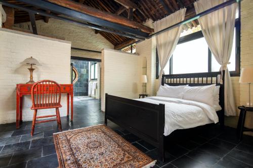 a bedroom with a bed and a chair and a desk at Brickyard Retreat at Mutianyu Great Wall Adjoin to Mutianyu Great Wall - Room with the View of Great Wall - Chinese massage experience - Vehicle Shuttle Service - International Catering - SPA& Nail Beauty Facilities in Huairou