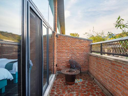 a balcony with a brick wall and a bucket at Brickyard Retreat at Mutianyu Great Wall Adjoin to Mutianyu Great Wall - Room with the View of Great Wall - Chinese massage experience - Vehicle Shuttle Service - International Catering - SPA& Nail Beauty Facilities in Huairou
