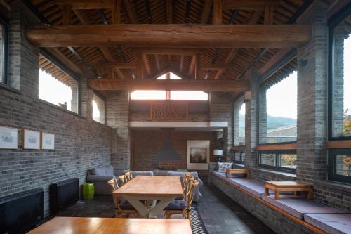 a large room with a wooden table and chairs at Brickyard Retreat at Mutianyu Great Wall Adjoin to Mutianyu Great Wall - Room with the View of Great Wall - Chinese massage experience - Vehicle Shuttle Service - International Catering - SPA& Nail Beauty Facilities in Huairou
