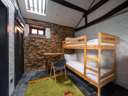 a bedroom with bunk beds in a brick wall at Brickyard Retreat at Mutianyu Great Wall Adjoin to Mutianyu Great Wall - Room with the View of Great Wall - Chinese massage experience - Vehicle Shuttle Service - International Catering - SPA& Nail Beauty Facilities in Huairou