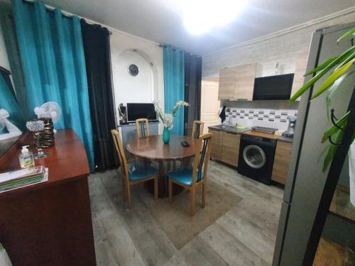 une cuisine avec une table et des chaises ainsi qu'une salle à manger dans l'établissement Bel petit appartement, à Charleville-Mézières