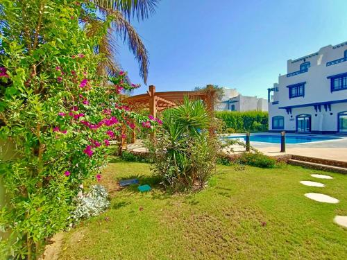 a garden with pink flowers and a building at Luxury Villa with pool in Hurghada in Hurghada
