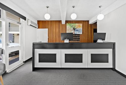 
a kitchen with a white counter top and white cabinets at Park Motor Inn in Toowoomba
