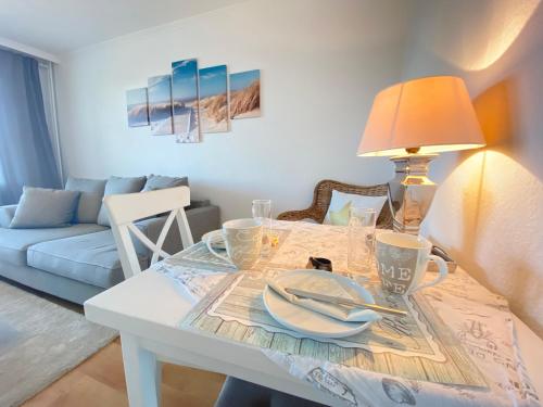 a dining room table with plates and a lamp at Ferienwohnung "Sylt Sunrise" in Westerland (Sylt)