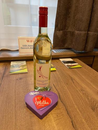 a bottle of wine sitting on a table at Romantikapartment mit Sommercard in Ramsau am Dachstein