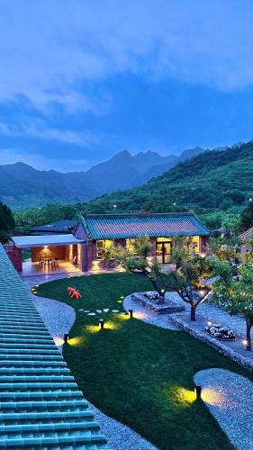 a house with a large yard with a pond at Brickyard Retreat at Mutianyu Great Wall Adjoin to Mutianyu Great Wall - Room with the View of Great Wall - Chinese massage experience - Vehicle Shuttle Service - International Catering - SPA& Nail Beauty Facilities in Huairou