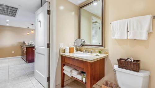 a bathroom with a sink and a toilet and a mirror at 1 BR Luxury Condo in Presitigious Honua Kai Resort #k430 in Lahaina