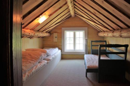 a attic room with a bed and a window at Lille Gjersdal - Et unikt opphold 100 år tilbake i tid in Farsund