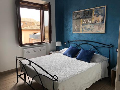 una camera da letto con un letto con pareti blu e una finestra di Appartamento Garibaldi a Orvieto