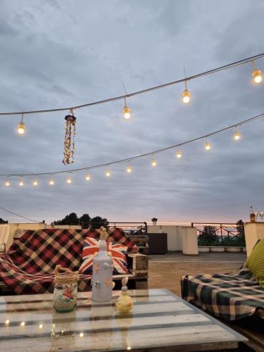 a patio with lights and a glass table with at Wonderland in Chakvi