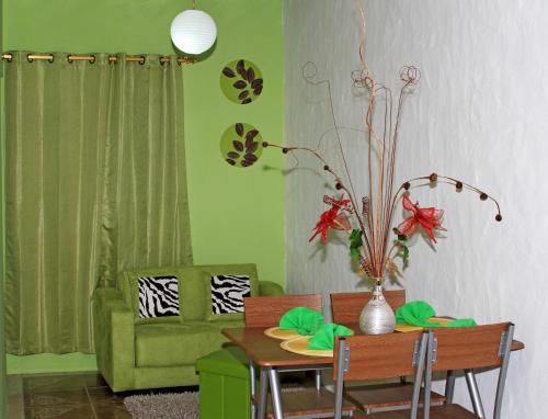 a living room with a table and a green couch at Zurisadai in Puerto Ayora