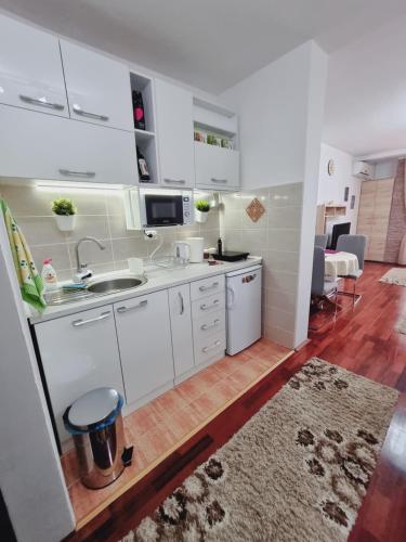 a small kitchen with white cabinets and a sink at Apartman Temida Lux in Vrnjačka Banja