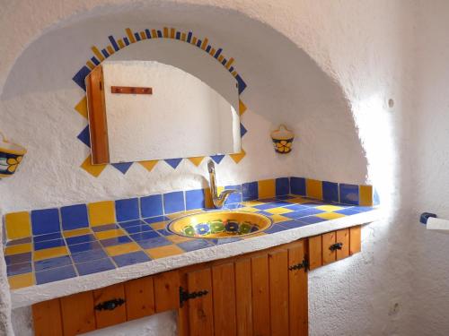 ein Bad mit einem Waschbecken und einem Spiegel in der Unterkunft Cueva Las Rosas-VTAR/GR/02108 in Guadix