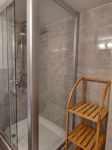 a shower with a wooden chair in a bathroom at Hawaii Holiday Apartment 41 in Limassol