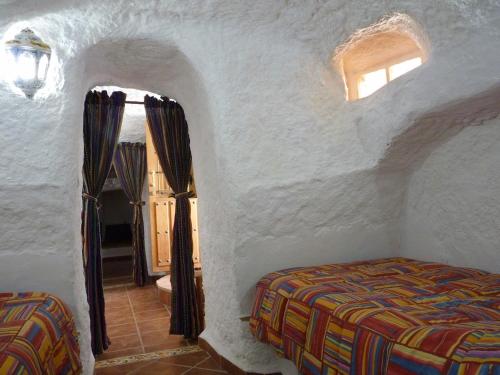 ein Schlafzimmer mit einem Bett in einem weißen Zimmer in der Unterkunft Cueva Las Rosas-VTAR/GR/02108 in Guadix